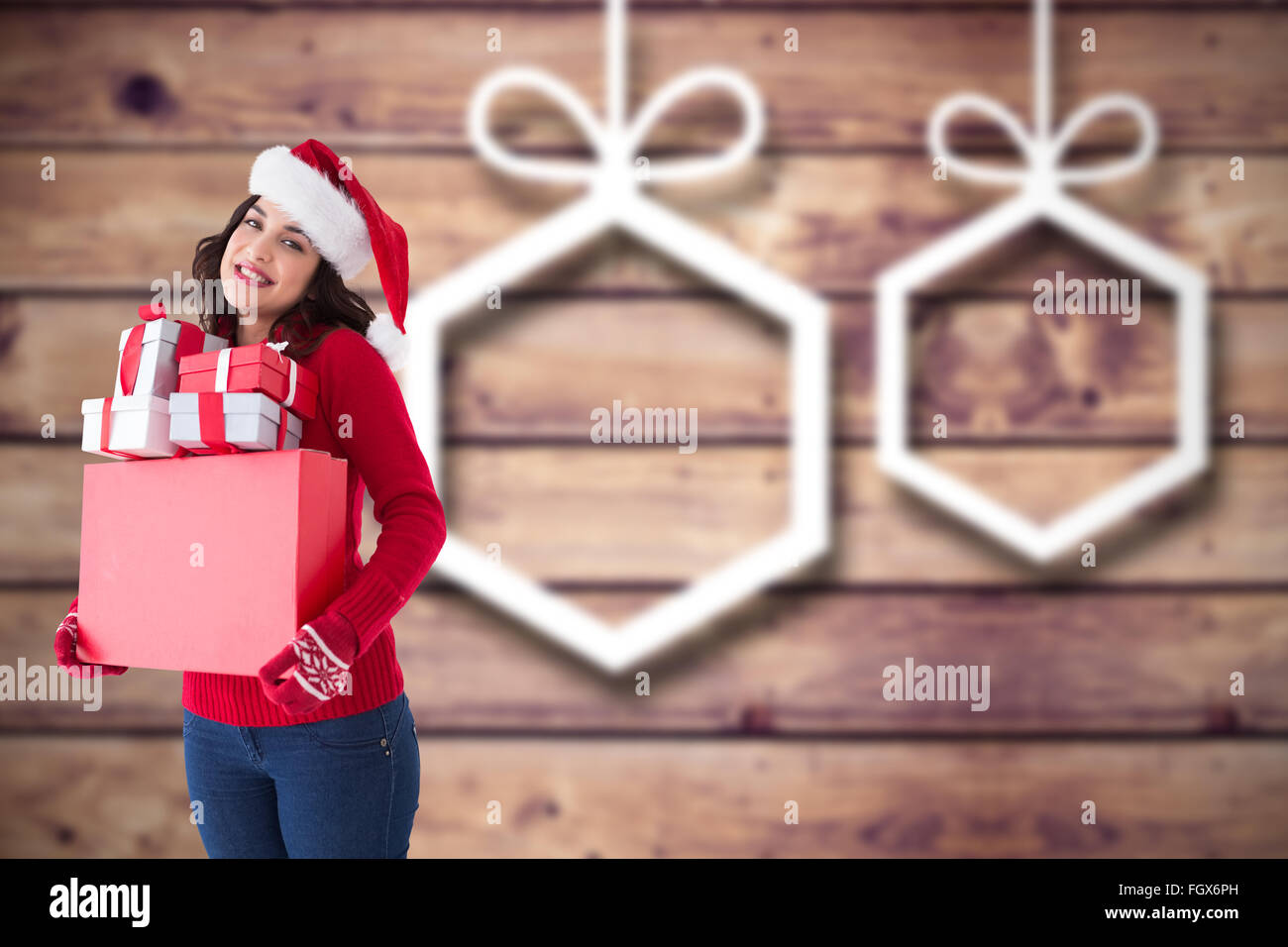 Immagine composita di felice brunette in santa hat holding molti doni Foto Stock