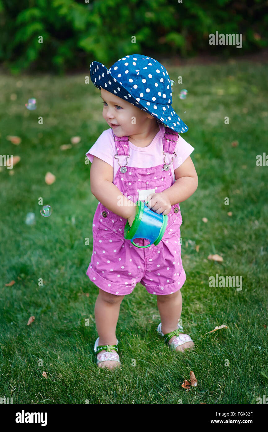 Bambina passeggiate nel parco sull'erba Foto Stock