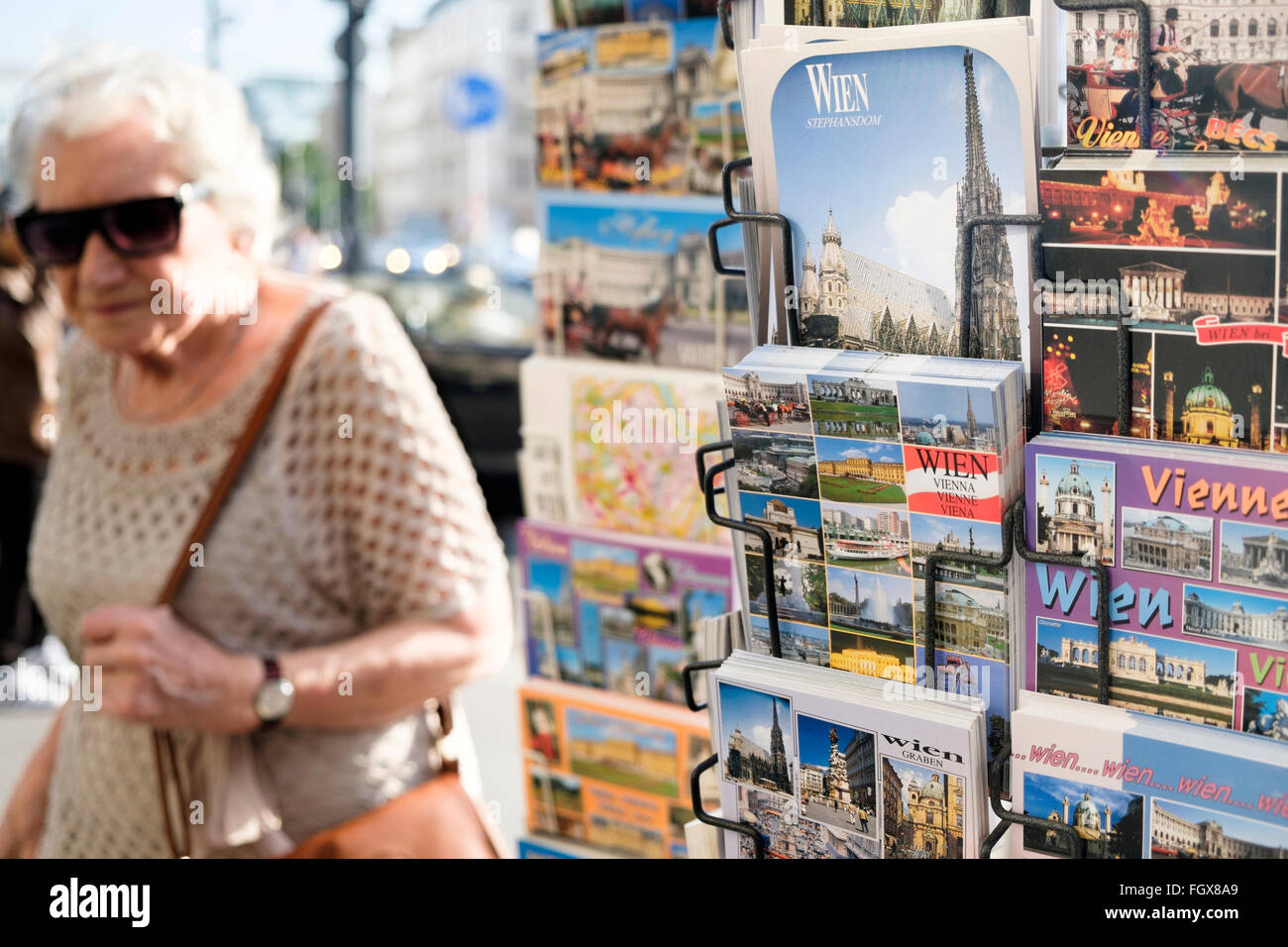 Una cartolina di stand a Vienna, Austria, con una signora anziana in background. Foto Stock