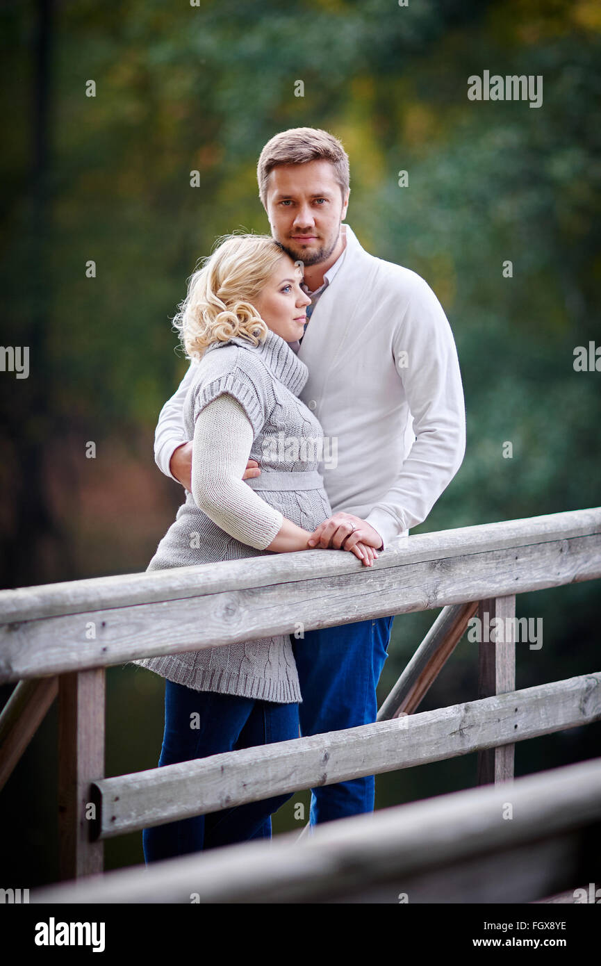 Giovane donna bionda con suo marito nel parco sul ponte Foto Stock