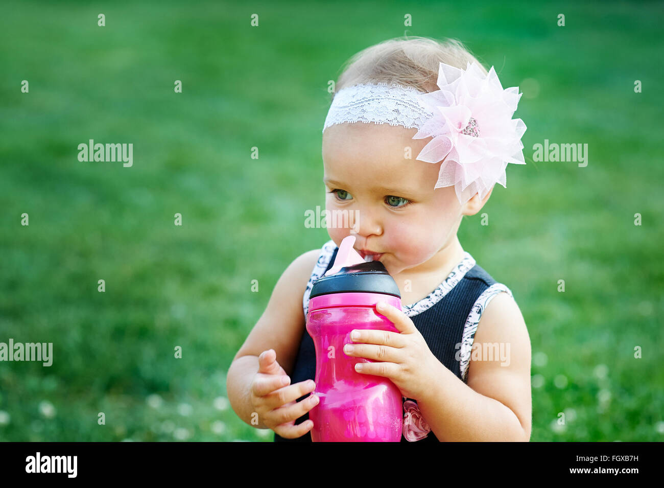 Felice bambina giocando in prato estivo sull'erba Foto Stock