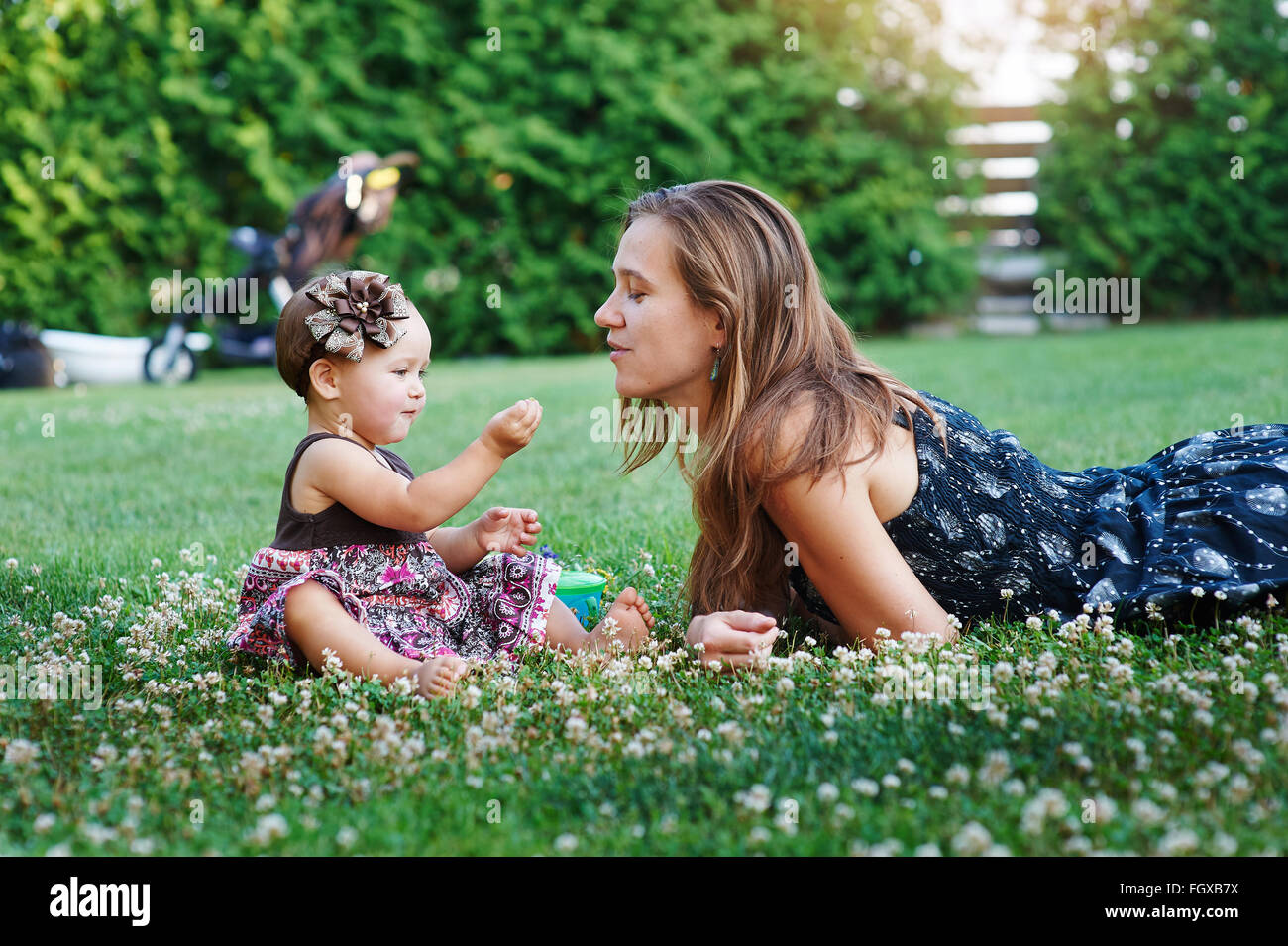 Giovane madre e la sua piccola figlia giocando sull'erba Foto Stock