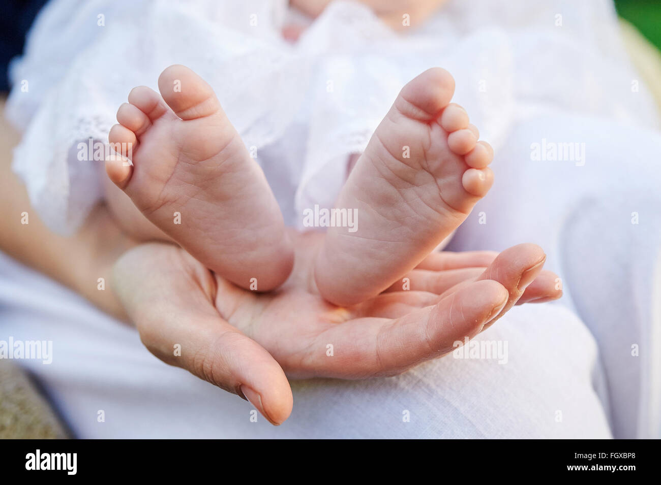 Madre mano azienda piccoli piedi del bambino Foto Stock