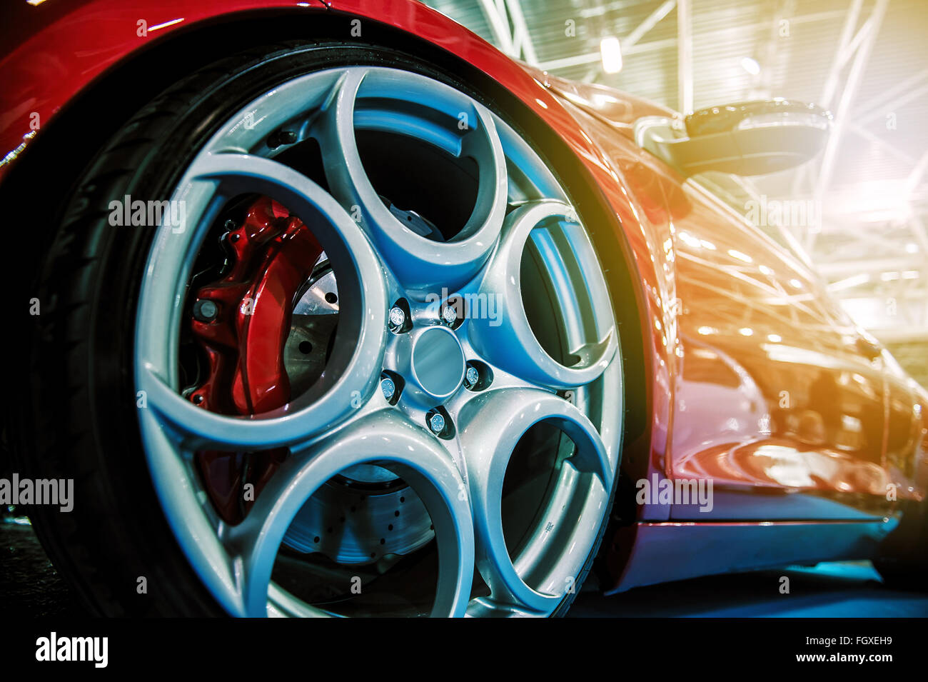 Rosso sport moderno auto illuminata in un salone Foto Stock