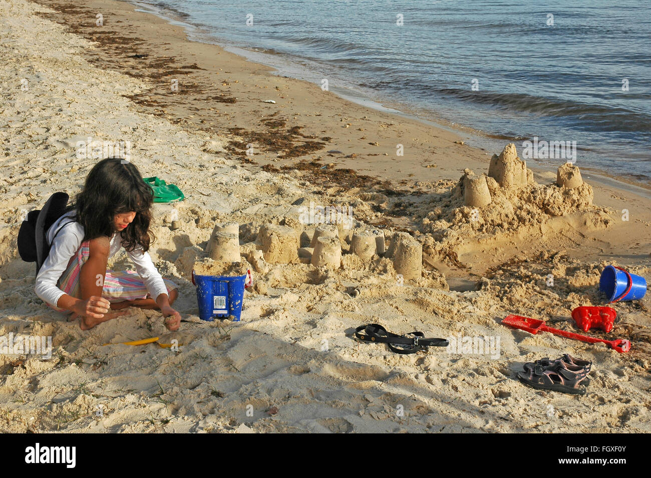 Nove anni ragazza australiana sandcastles edificio dal Fiume Swan, Perth, Western Australia. Foto Stock