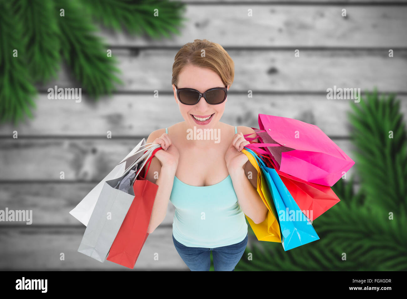 Immagine composita della donna azienda shopping bags indossando occhiali da sole Foto Stock