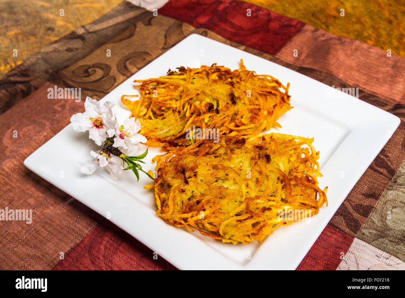 Latkes di patate servita con fiori di mandorla Foto Stock