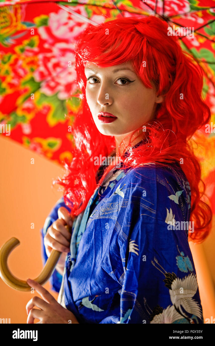 Ragazza con i capelli rossi e ombrello coloratissimo Foto Stock