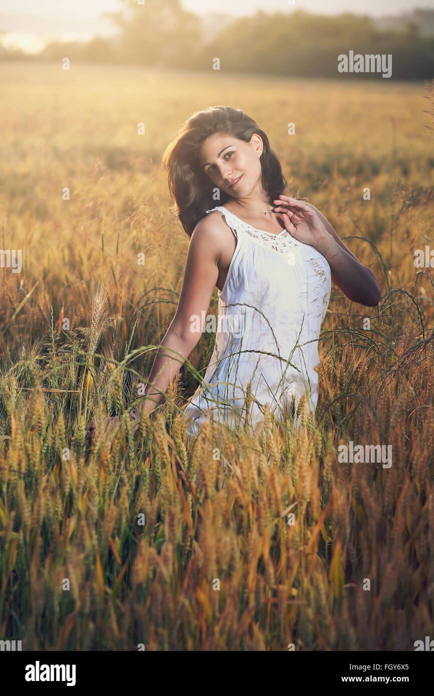 Ritratto di una donna bella in un campo. In estate la luce del tramonto Foto Stock