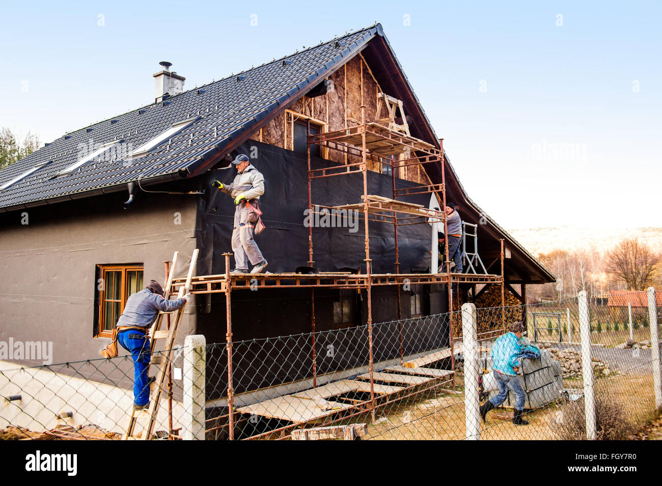 Operai della costruzione isolante termicamente casa con lana di vetro Foto Stock