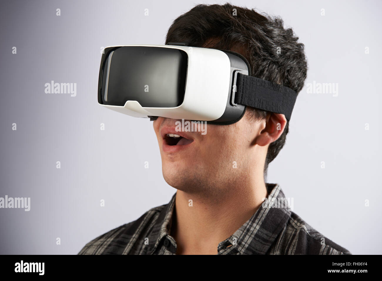 Giovane uomo che indossa la realtà virtuale auricolare Foto Stock