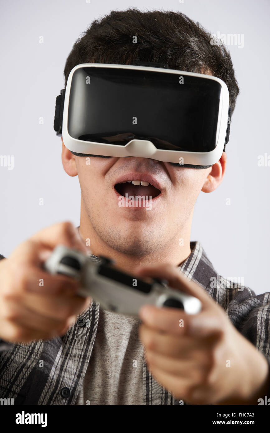 L'uomo la riproduzione di video gioco indossando la realtà virtuale auricolare Foto Stock