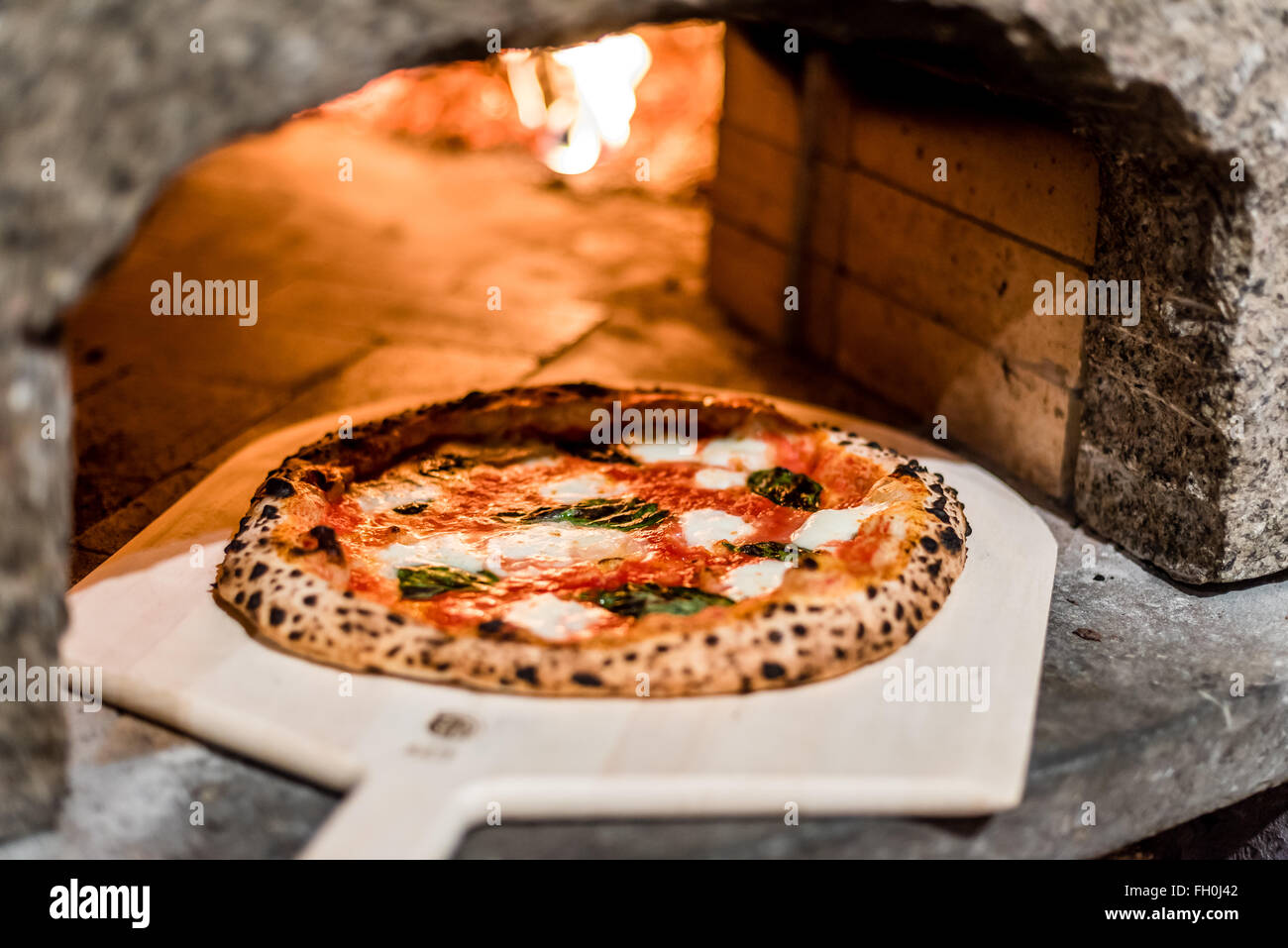 Margarita pizza andando in un forno di mattoni Foto Stock