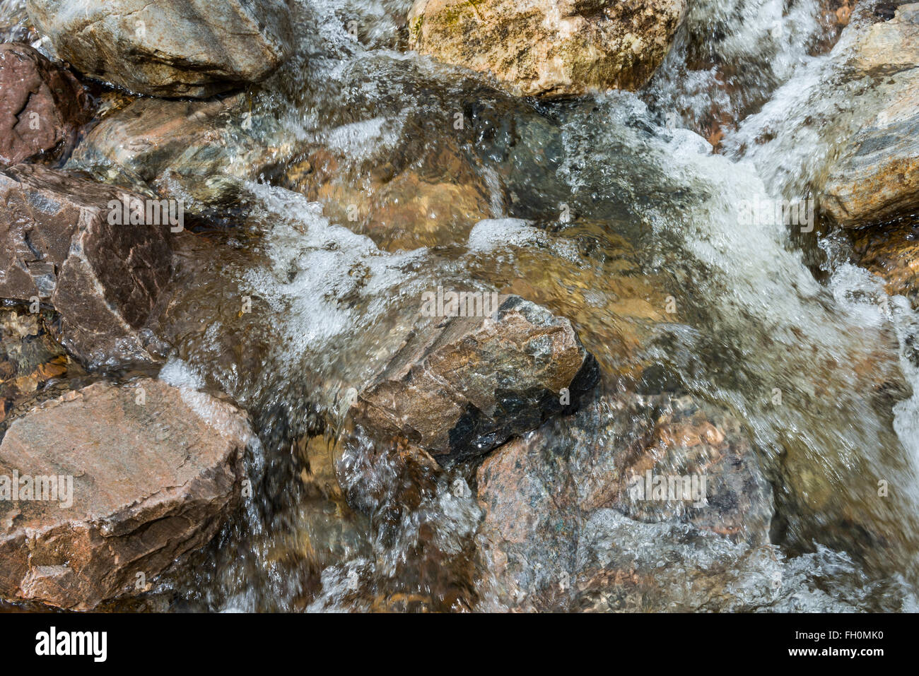 Creek che scorre veloce con acqua con rocce nel torrente. Foto Stock