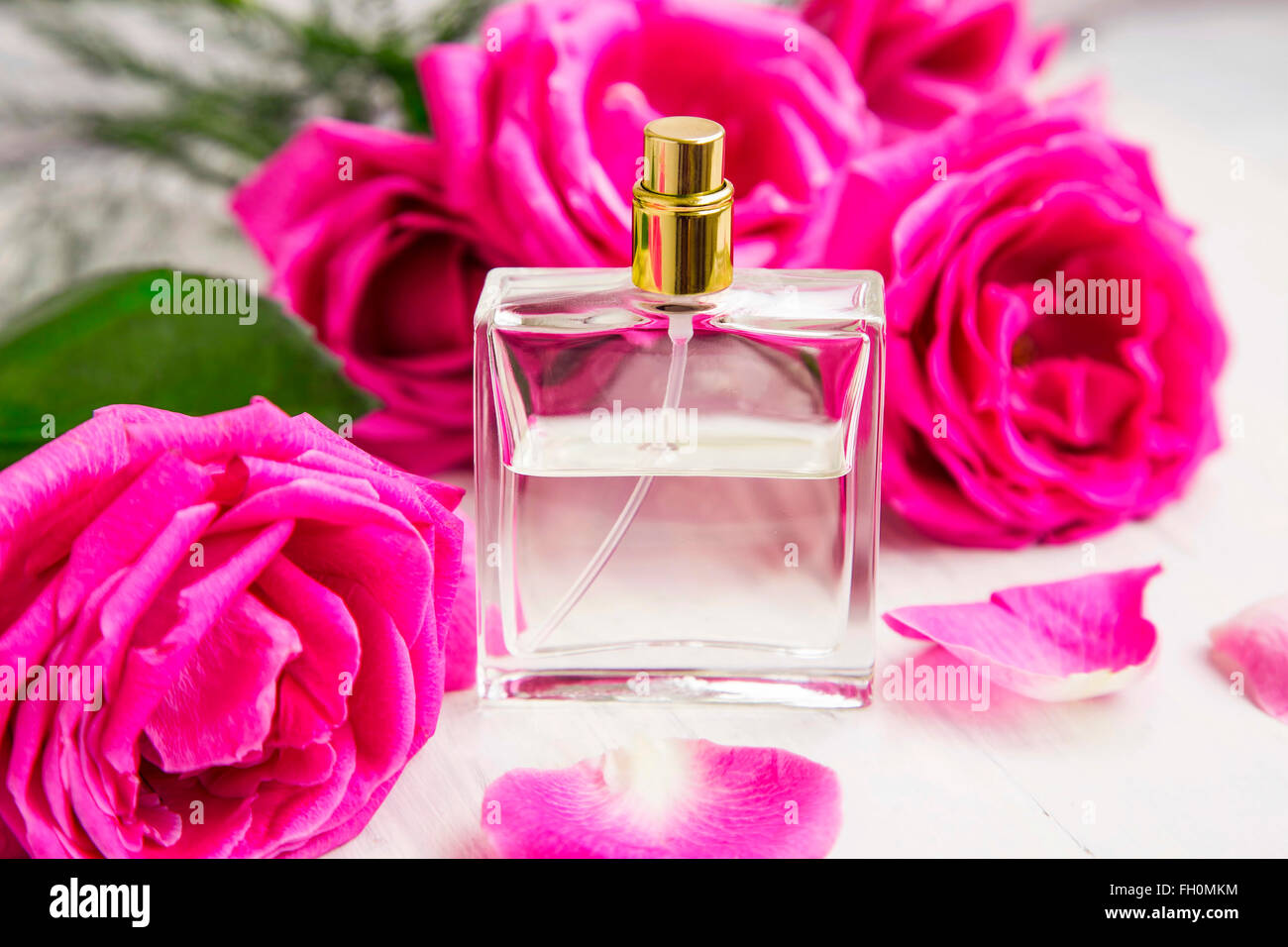 Profumo di rose in bottiglia trasparente con rosa profumo floreale di rose Foto Stock