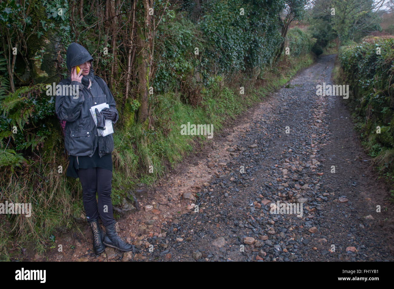 Un camminatore su Dartmoor colloqui sul suo telefono cellulare Foto Stock