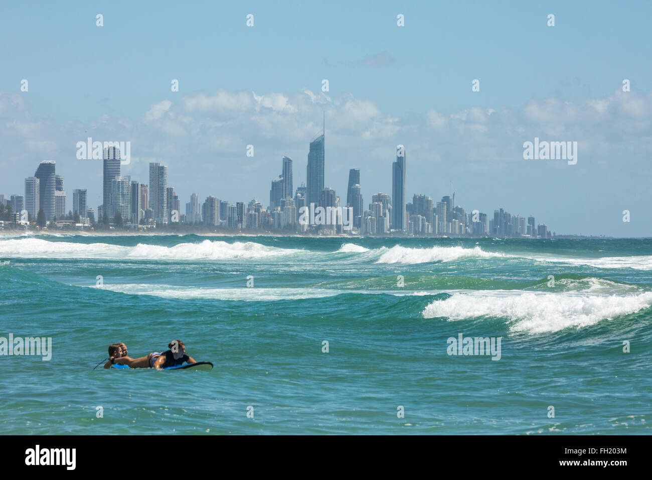 Surfisti a Burleigh capi del Queensland Gold Coast con Surfers Paradise a distanza,l'Australia Foto Stock