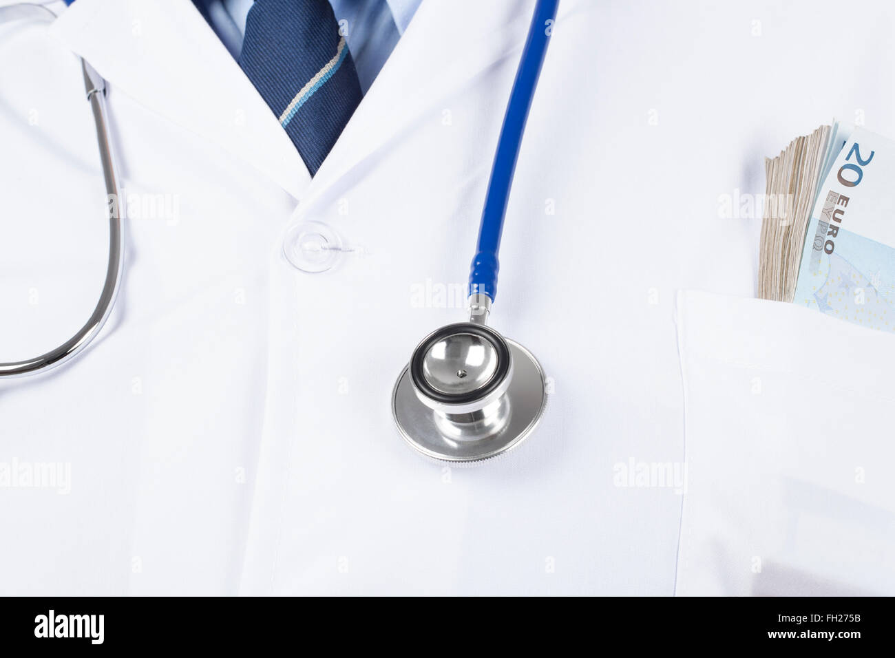 Dottore in tunica bianca con uno stetoscopio e borra di soldi in tasca. Foto Stock