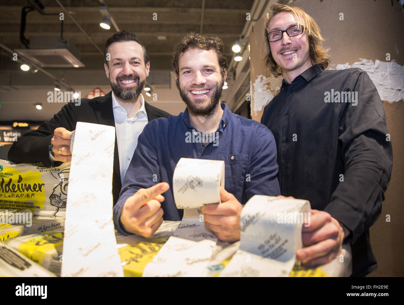 Christoph Woehlke (L-R), general manager del farmaco Budnikowsky catena di negozi, Benjamin Adrion, fondatore dell'acqua potabile iniziativa "Viva con Agua' e ex calciatore professionista di FC St Pauli e Enno Schroeder di Goldeimer Komposttoiletten (lit. Golden benna compost toilette) presente 'Goldeimer Klopapier' (Golden benna carta igienica) durante un evento stampa in corrispondenza di un ramo del farmaco catena negozio Budnikowski ad Amburgo, Germania, 23 febbraio 2016. La sede ad Amburgo iniziativa "Viva con Agua' intende raccogliere donazioni per le strutture sanitarie in Ethopia vendendo la carta igienica. In Foto Stock