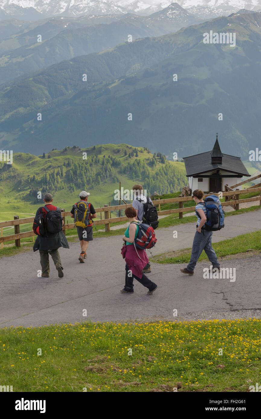 Un gruppo di escursionisti passando una piccola chiesa sul Kitzbuheler Horn in Kitzbuhel, Austria. Europa Foto Stock