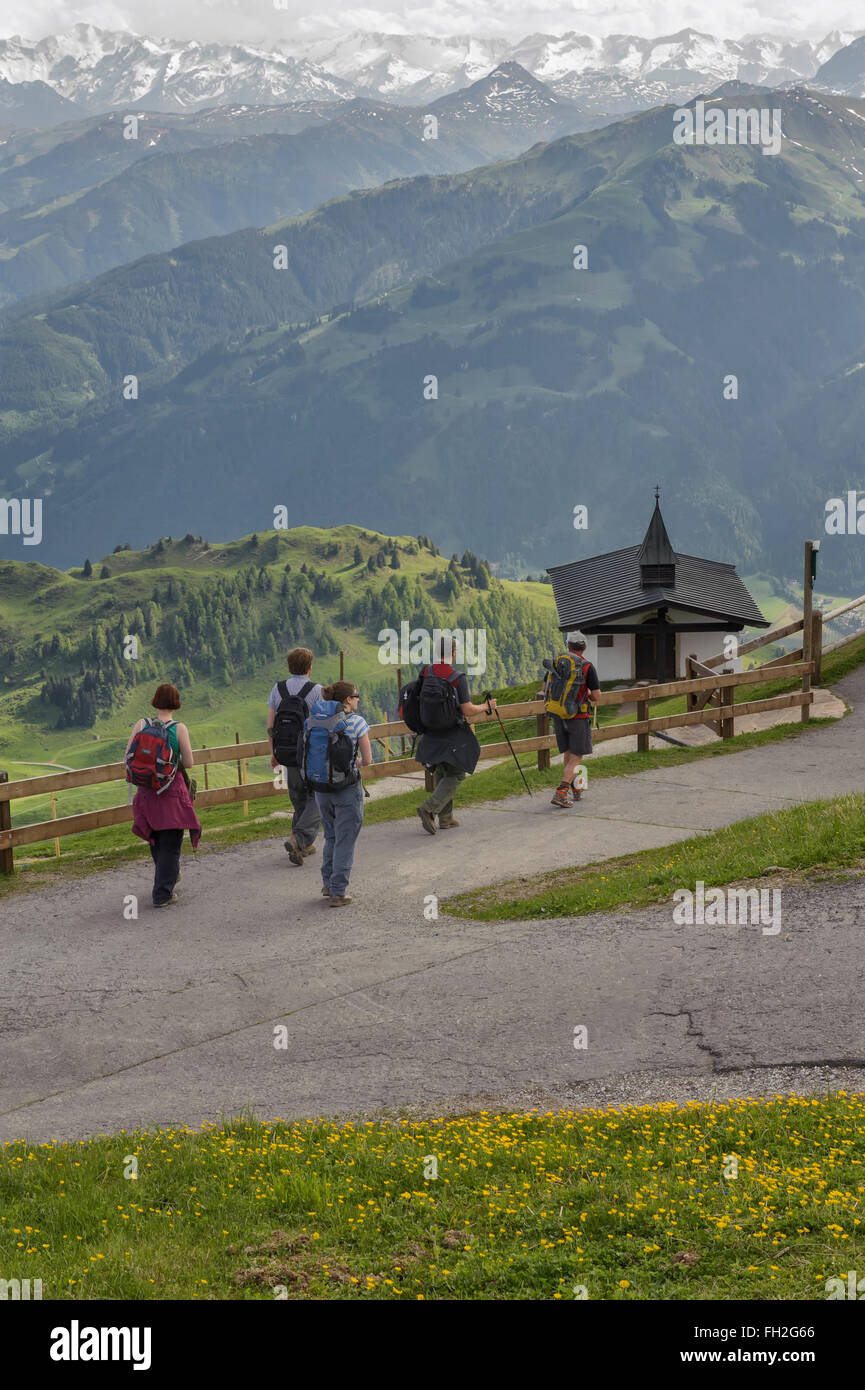 Un gruppo di escursionisti passando una piccola chiesa sul Kitzbuheler Horn in Kitzbuhel, Austria. Europa Foto Stock