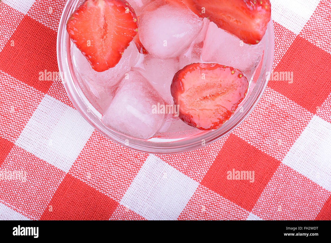 Una fetta di fragola rossa sulla lastra di vetro nella parte di sfondo a tema Foto Stock