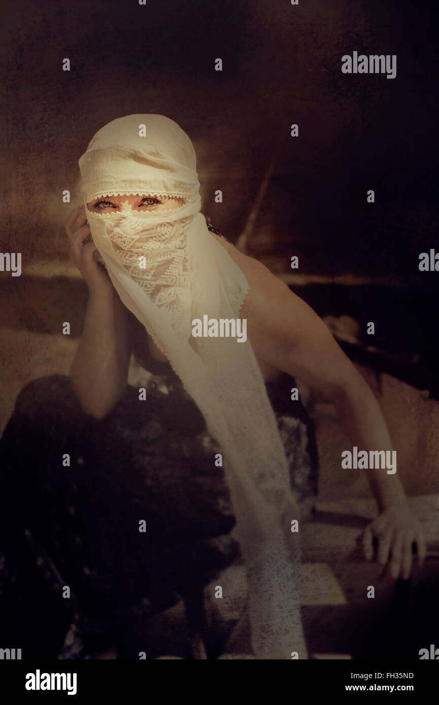 Donna vestita in stile arabo nasconde il suo volto Foto Stock
