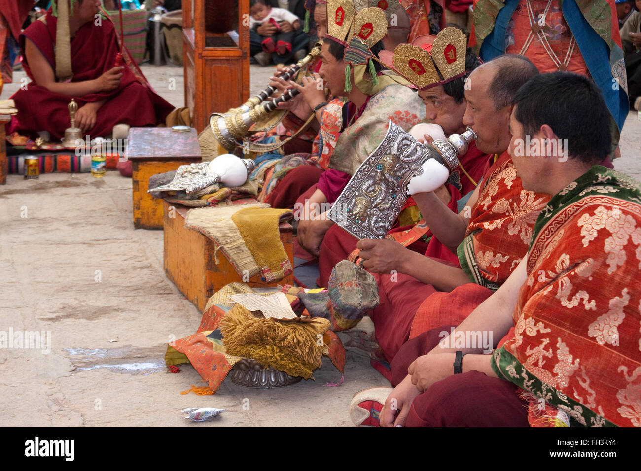 Monaci Tinetan suonare uno strumento musicale durante la Saga Dawa cerimonia al Pelko contese monastero Gyantse Shigatse Tibet Foto Stock