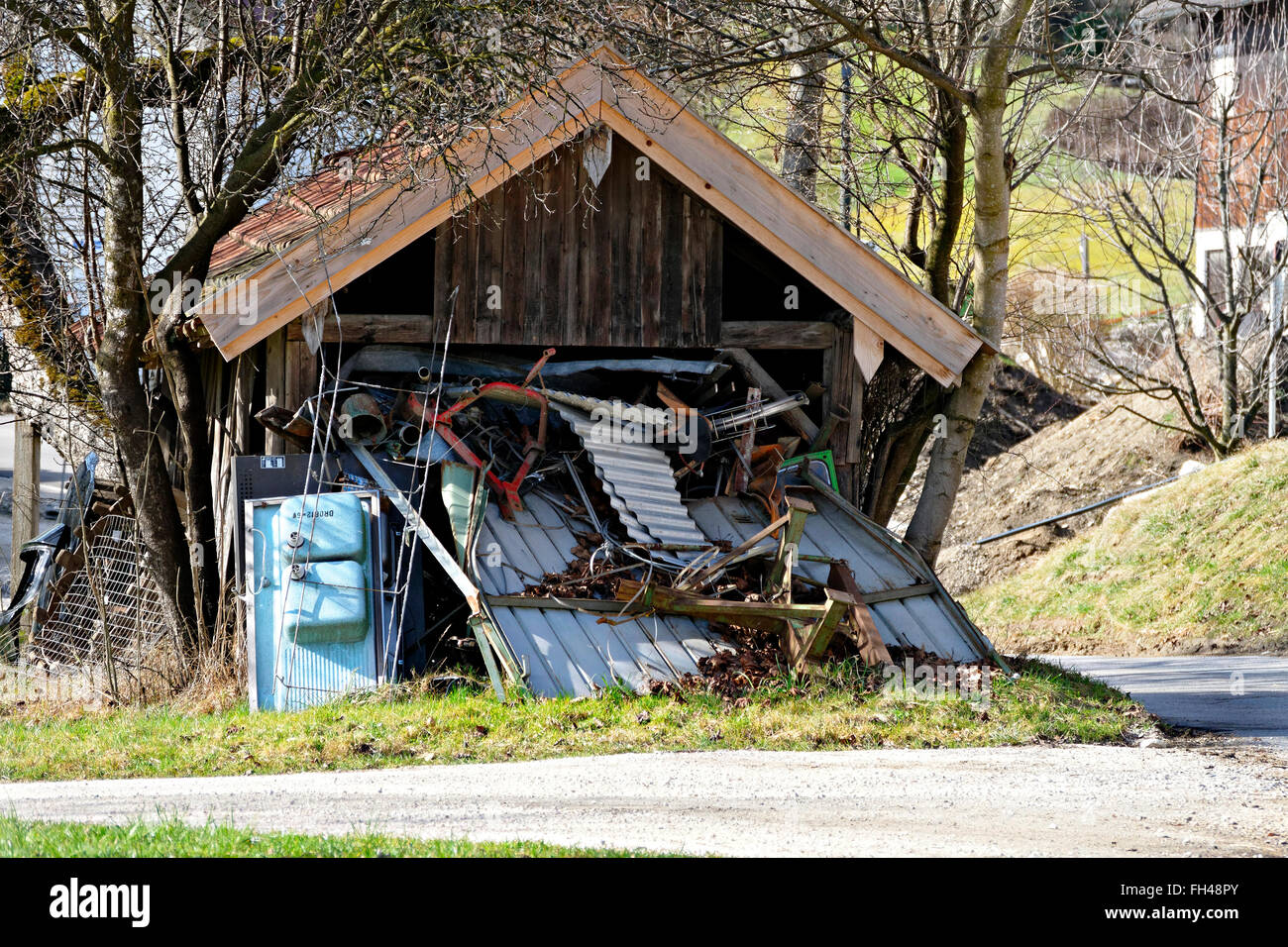 Vecchio capannone di legno traboccante di rottami di metallo, Chiemgau, Alta Baviera, Germania, Europa Foto Stock