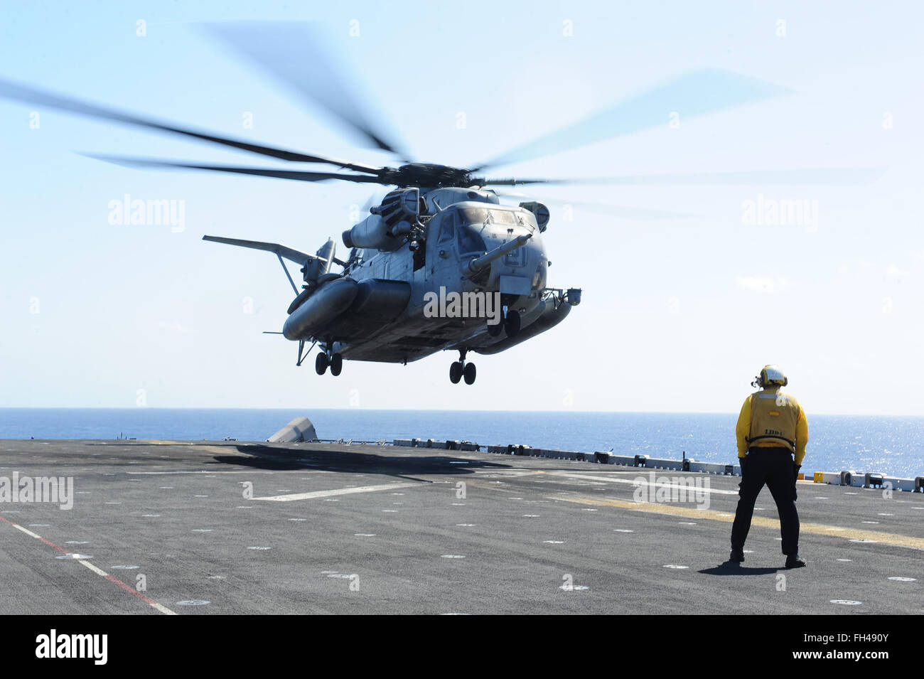 Oceano Pacifico (feb. 22, 2016) di aviazione di Boatswain Mate (movimentazione) Nicholas Ballard-Henry segnali a CH-53E Super Stallion, assegnato a mezzo marino di rotore inclinabile Squadron (VMM) 166 (rinforzato), sul ponte di volo di assalto anfibio nave USS Boxer (LHD 4). Più di 4.500 marinai e Marines da Boxer anfibio gruppo pronto e il tredicesimo Marine Expeditionary Unit (XIII MEU) sono in conduzione supporto formazione al largo delle Hawaii in preparazione per entrare negli Stati Uniti La quinta e la settima flotta aree di operazioni. Foto Stock