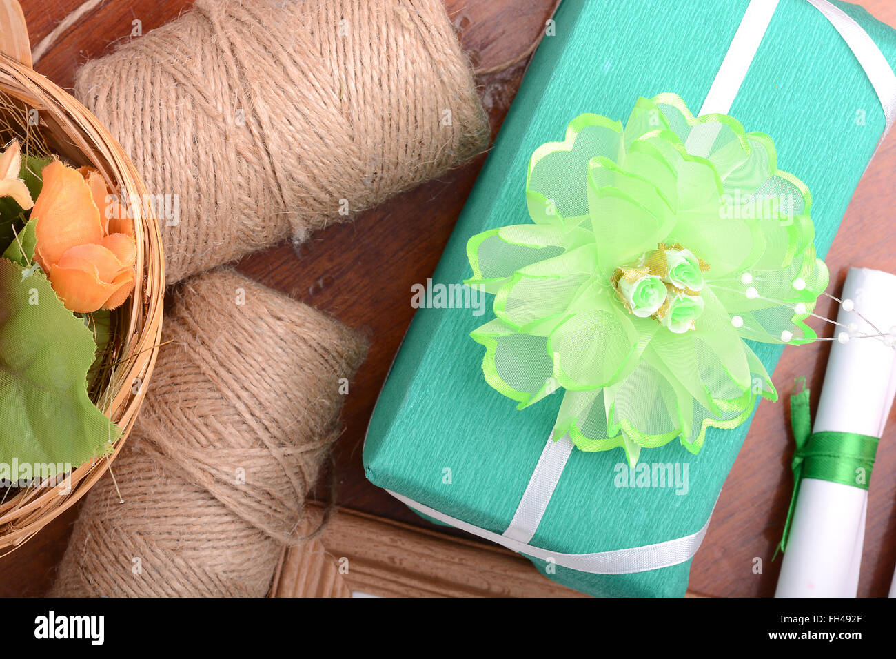 Verde di natale scatola regalo, libro bianco con fiocco sul tavolo di legno. Foto Stock