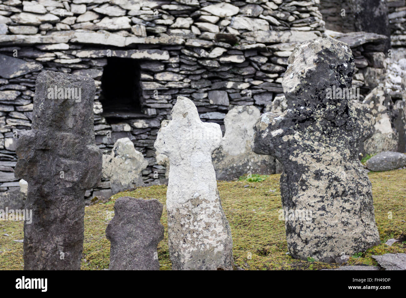 La pietra, scolpito a mano attraversa nel cimitero del monastero, Skellig Michael, Kerry, Irlanda Foto Stock