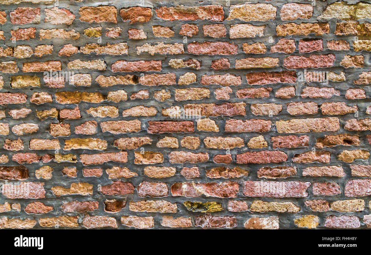 Un primo piano di vecchi mattoni su una parete a Venezia. Diversi i mattoni colorati può essere visto con il vecchio cemento tra loro. Foto Stock