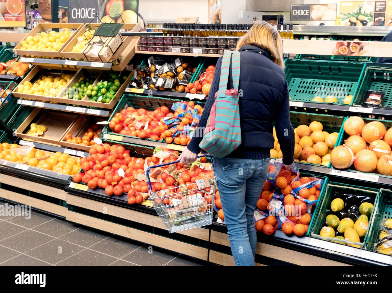 Una donna che acquista frutta e altri generi alimentari nel supermercato Tesco Aisle, Suffolk UK Foto Stock