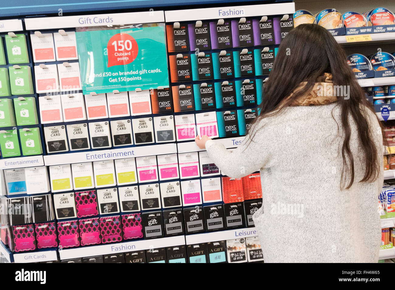 Giovane donna shopping per memorizzare le carte regalo, supermercato Tesco Suffolk REGNO UNITO Foto Stock