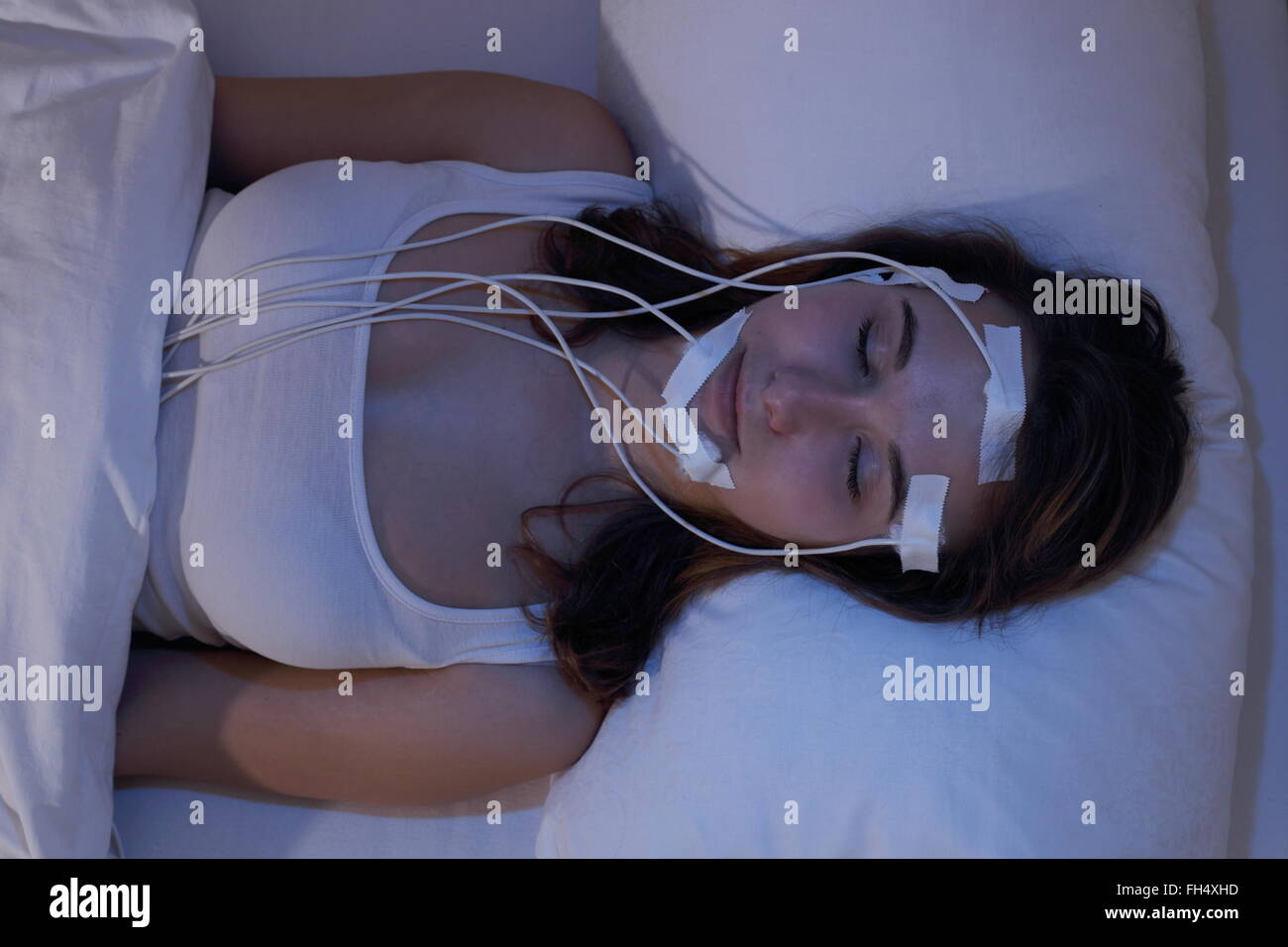 Una donna addormentata measering brainwaves eg in un laboratorio del sonno Foto Stock