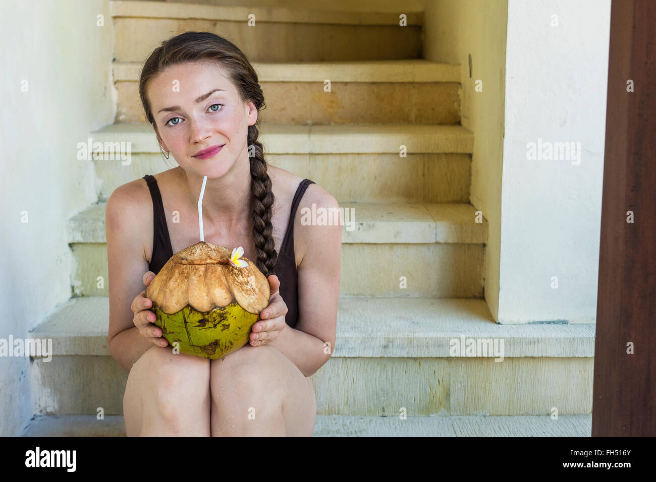 Giovane donna godendo di un cocco fresco Foto Stock
