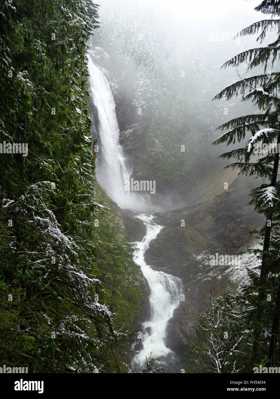 Cascata nelle montagne dello stato di Washington durante la caduta di neve Foto Stock