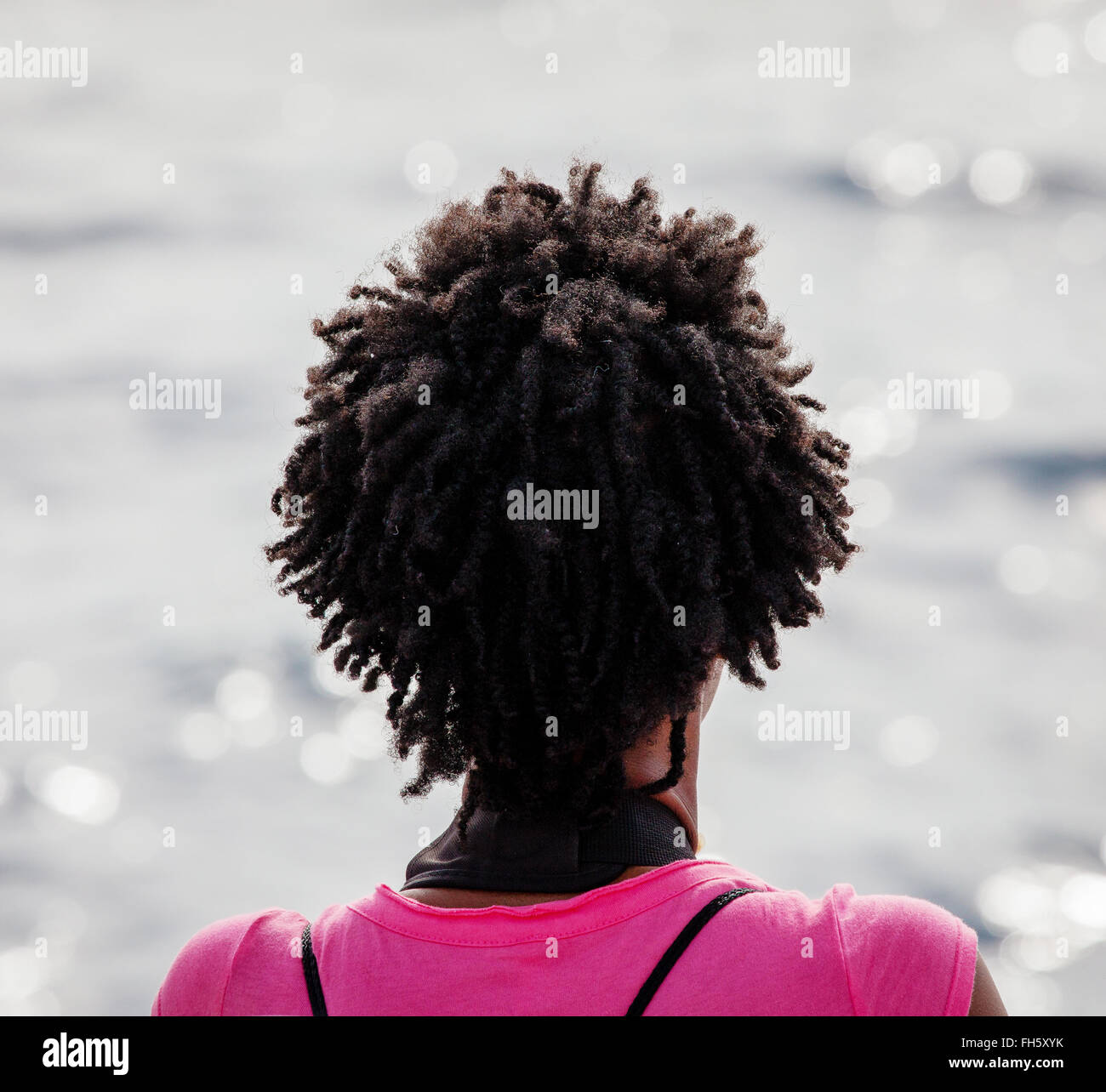 Una donna con serrature di serpente che guarda al mare da una barca a vela- Dominica West Indies Foto Stock