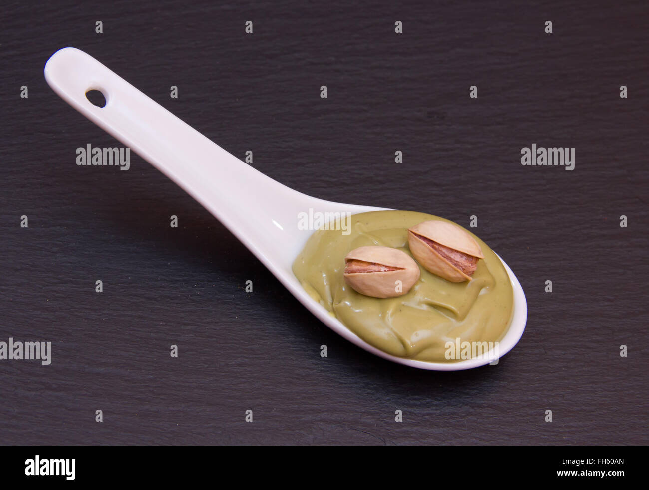 Crema di Pistacchio sul cucchiaio sulla sommità di ardesia Foto Stock