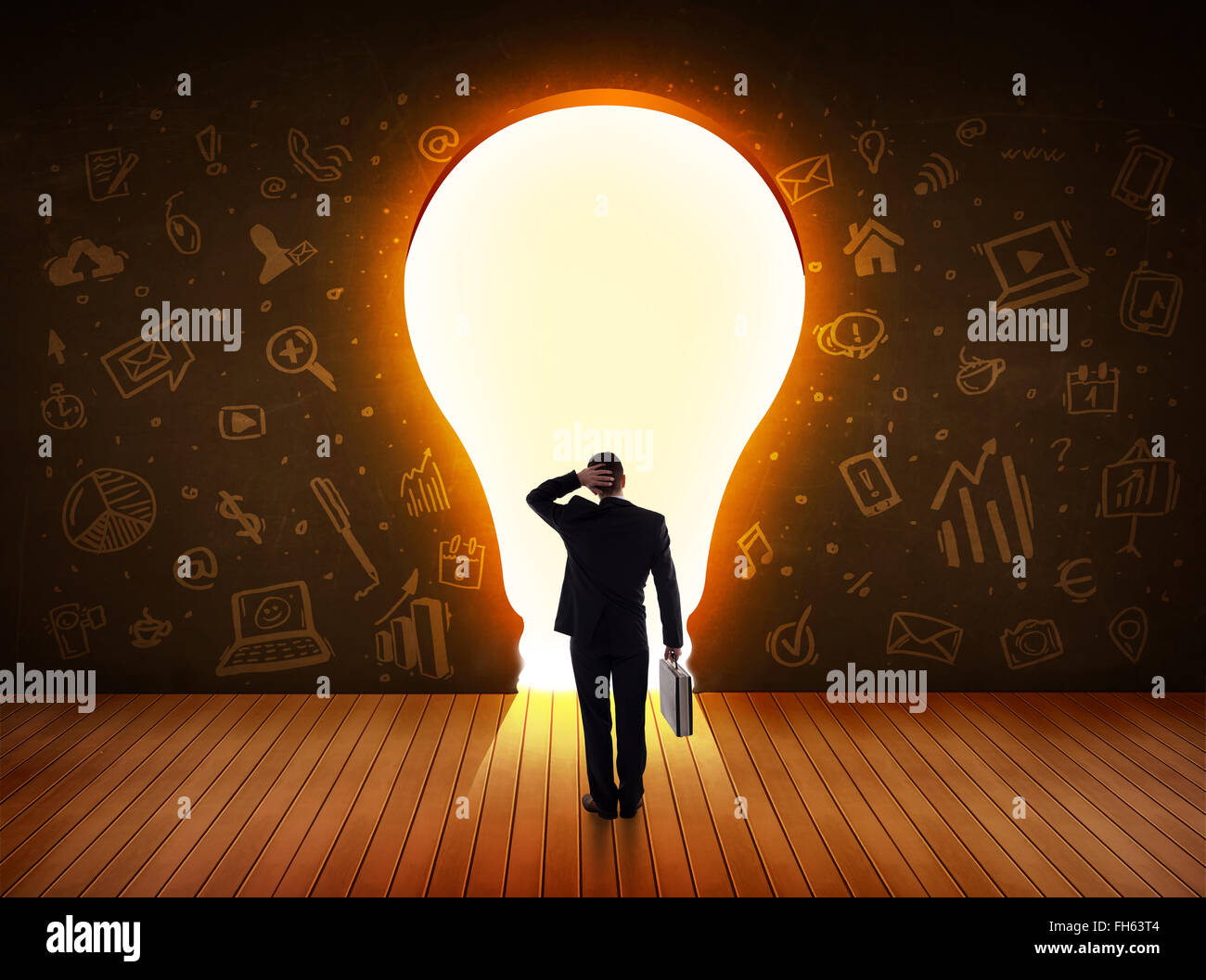 Business man guardando alla luce brillante lampadina nella parete Foto Stock