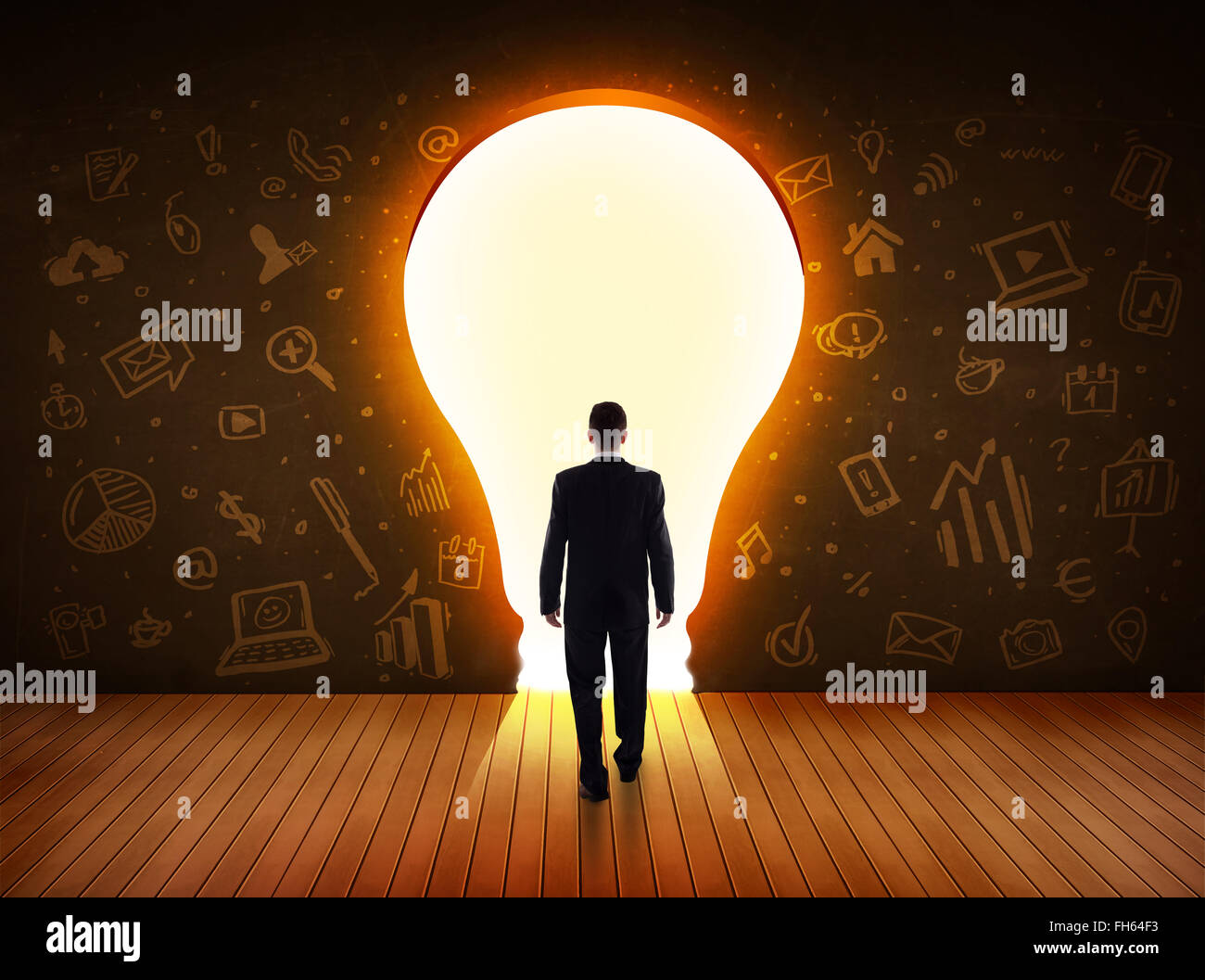 Business man guardando alla luce brillante lampadina nella parete Foto Stock