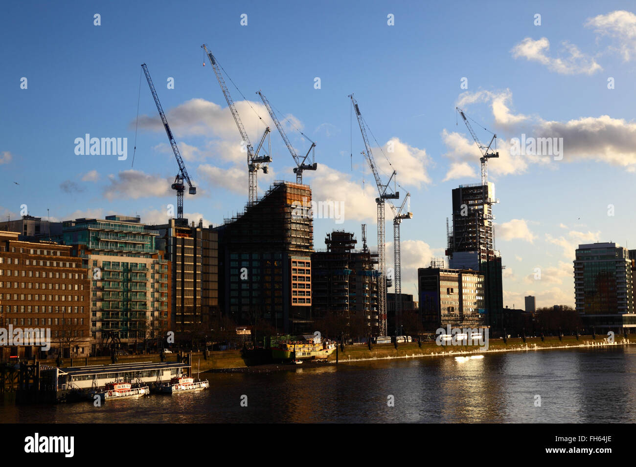Siti di costruzione e gru su Albert Embankment accanto al fiume Tamigi, visto da di Lambeth Bridge, London, England Regno Unito Foto Stock