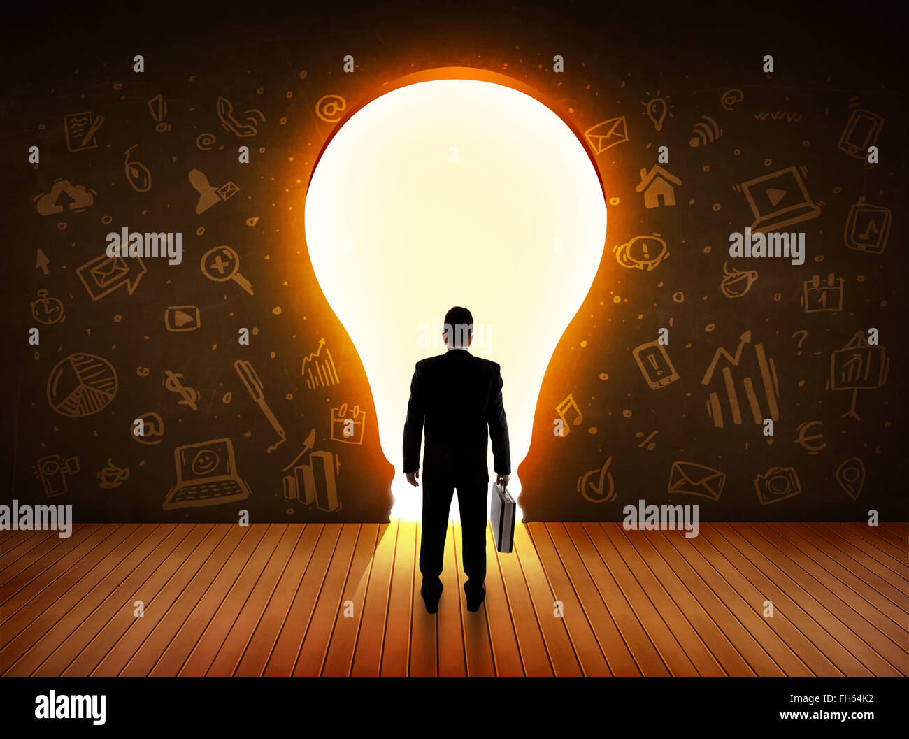 Business man guardando alla luce brillante lampadina nella parete Foto Stock