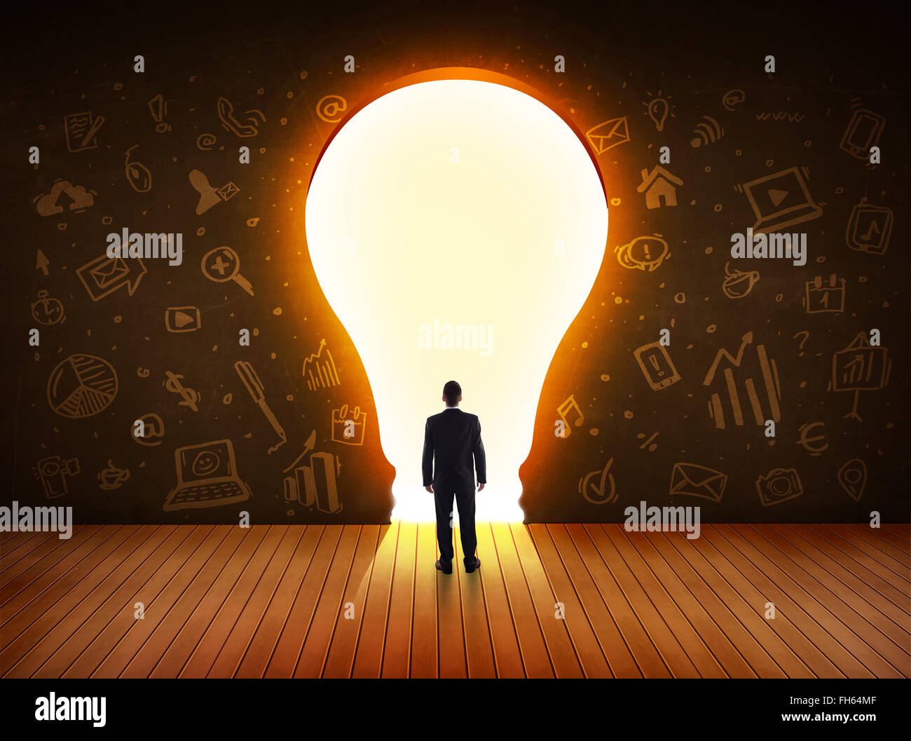 Business man guardando alla luce brillante lampadina nella parete Foto Stock