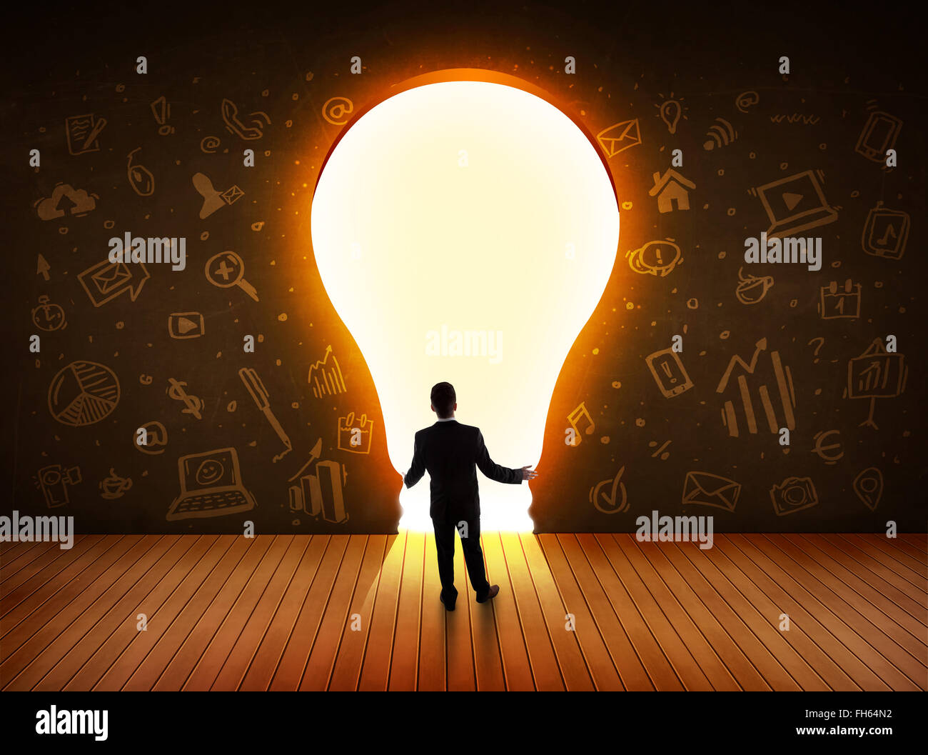 Business man guardando alla luce brillante lampadina nella parete Foto Stock