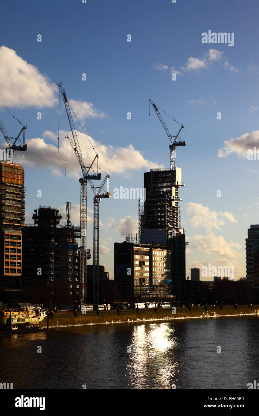 Siti di costruzione e gru su Albert Embankment accanto al fiume Tamigi, visto da di Lambeth Bridge, London, England Regno Unito Foto Stock