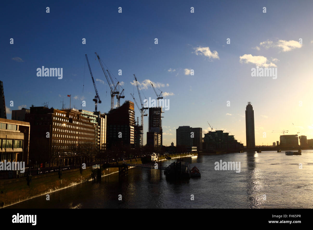 Siti di costruzione e gru su Albert Embankment accanto al fiume Tamigi, visto da di Lambeth Bridge, London, England Regno Unito Foto Stock