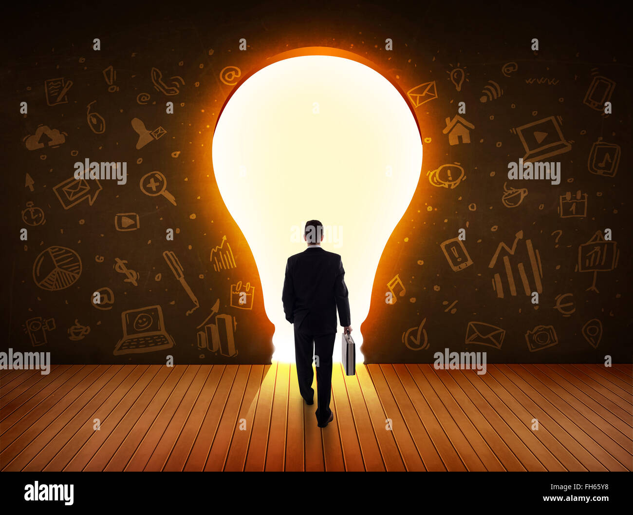 Business man guardando alla luce brillante lampadina nella parete Foto Stock