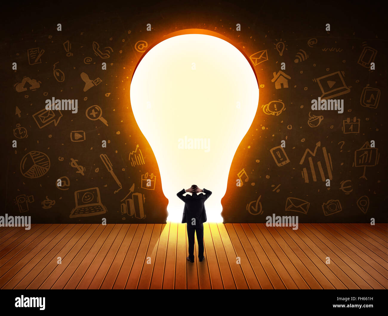 Business man guardando alla luce brillante lampadina nella parete Foto Stock